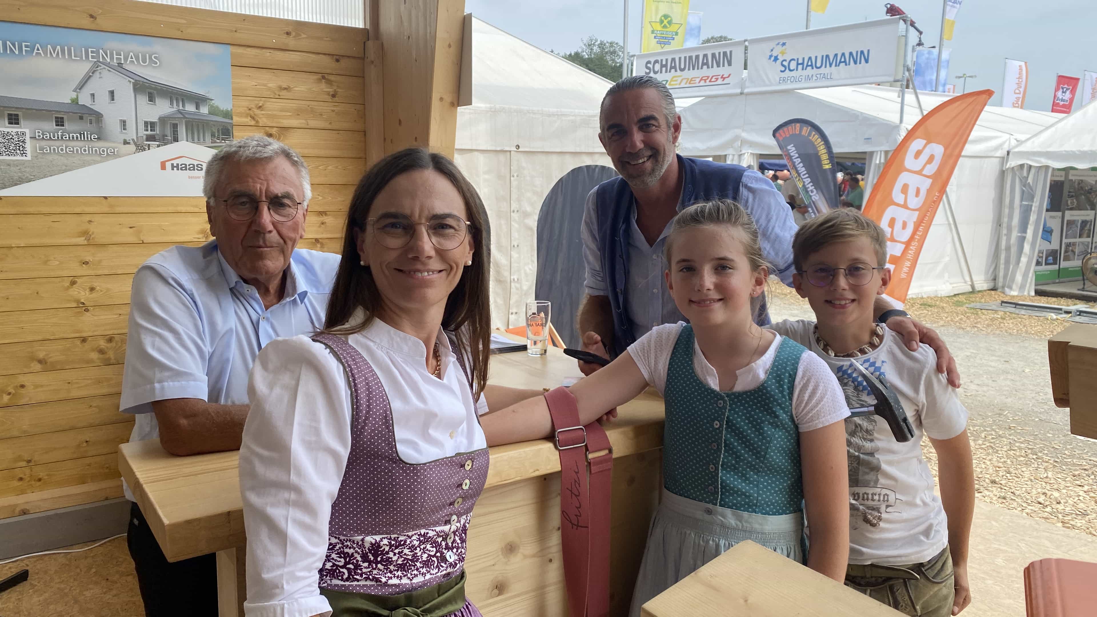 Familie in Tracht posiert für ein Foto am Haas Messestand, Rottalschau 2024 in Karpfham