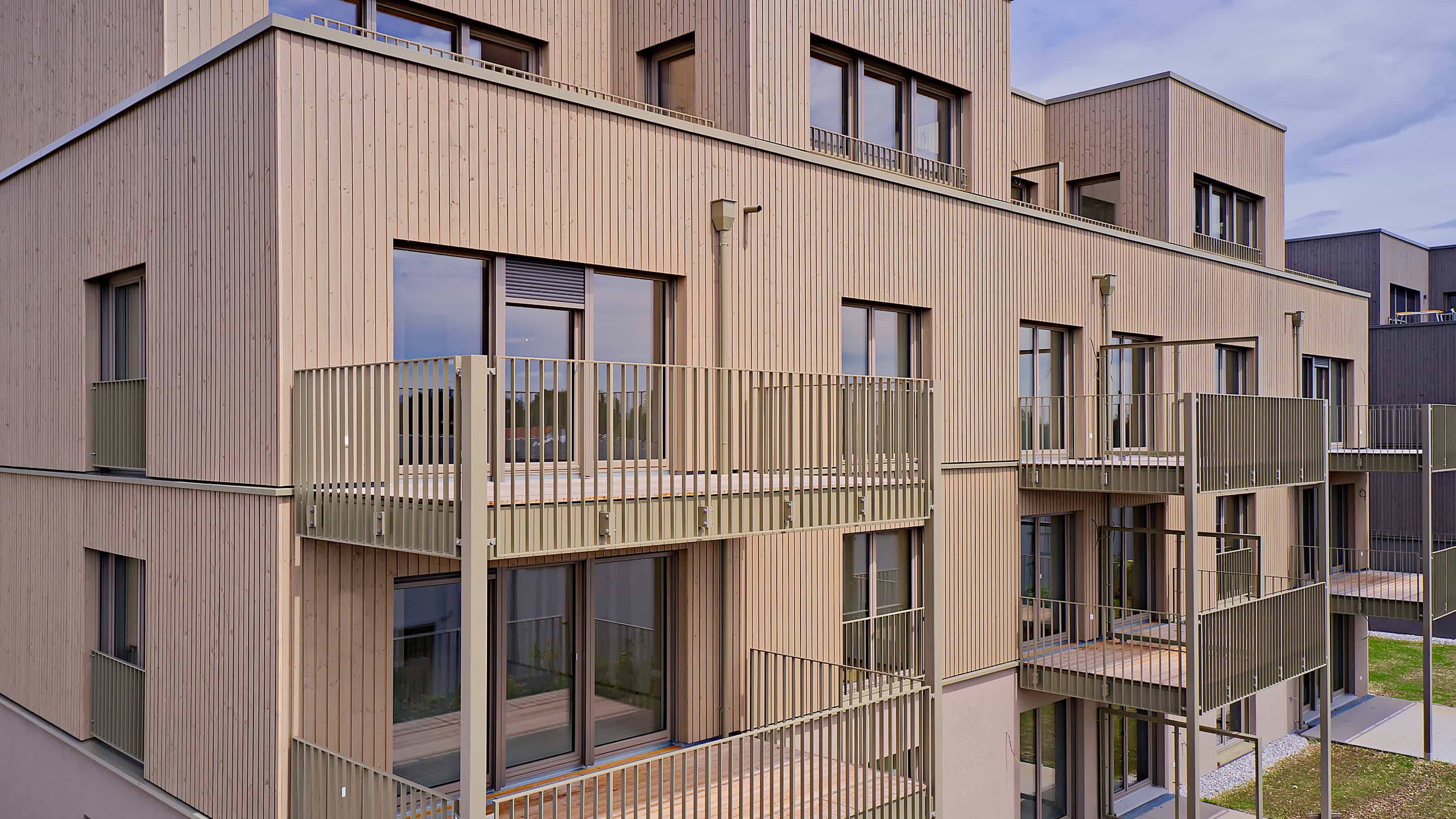 Holzfassade mit Balkonen der Mehrfamilienhäuser im Mehrgenerationen-Wohnquartier im Pfaffenwinkel