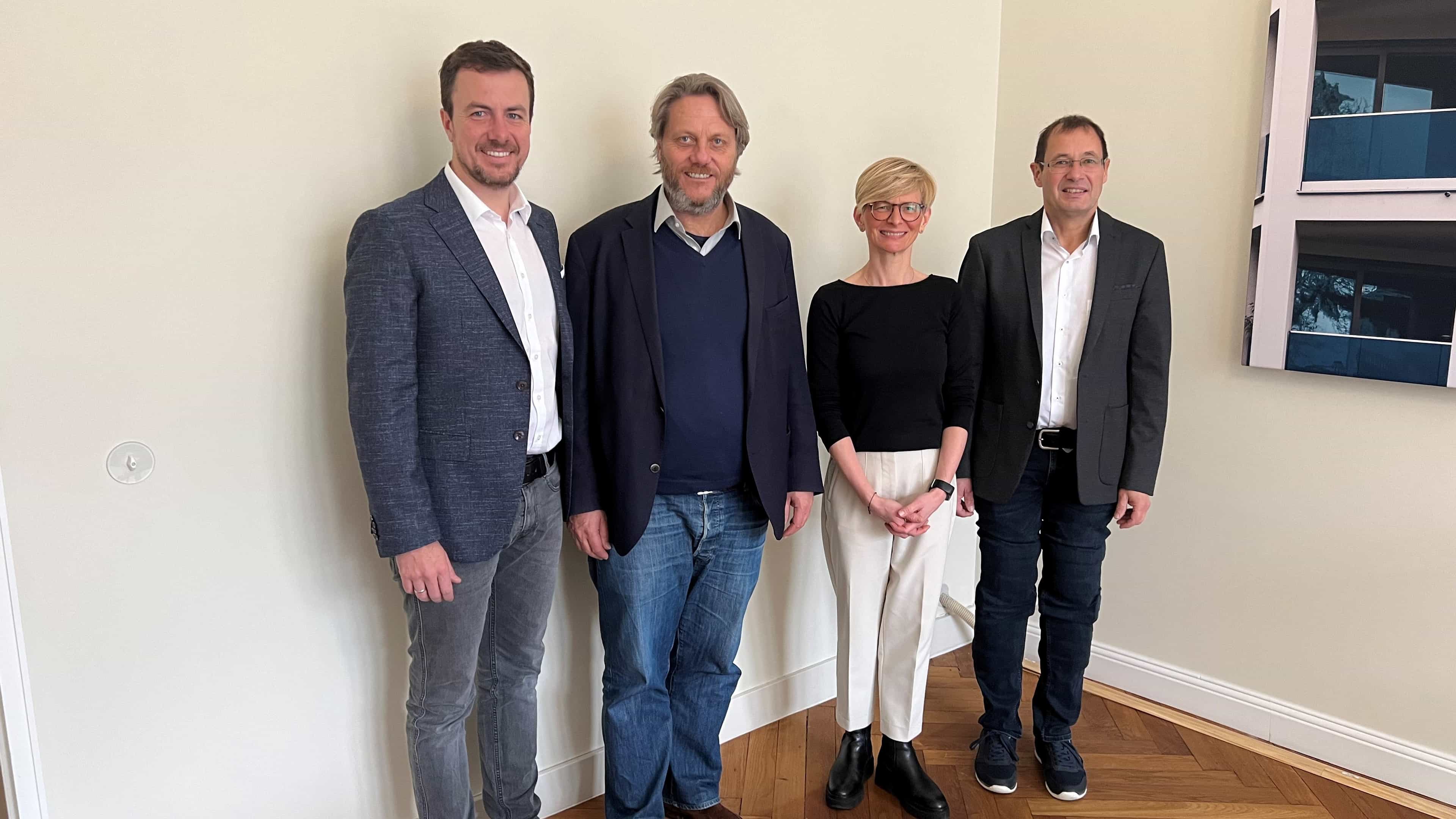 Vier Projektbeteiligte beim Gruppenfoto im Büro, Haas Fertigbau auf dem 5. Holzbaukongress in Berlin