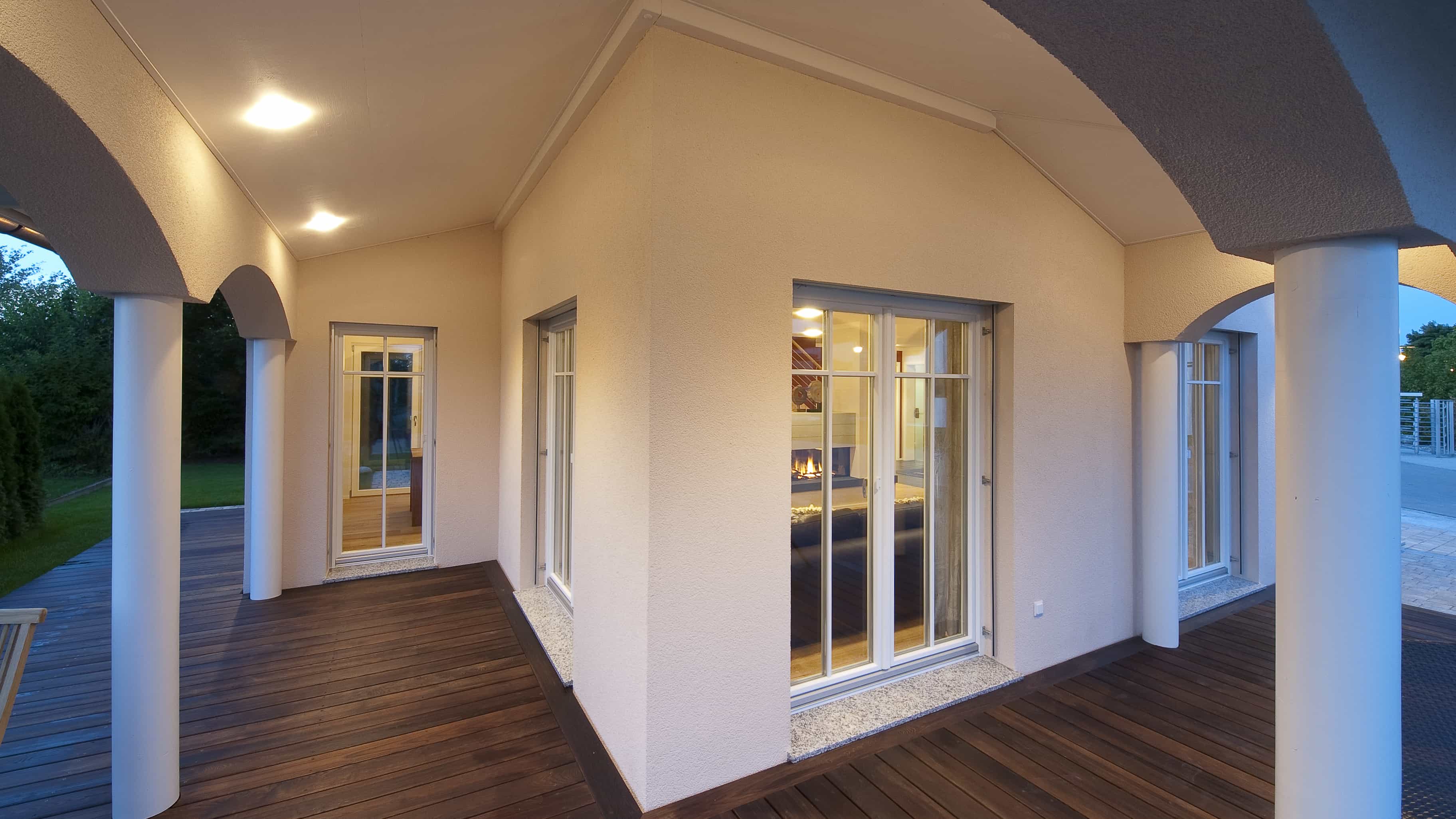 Überdachte Loggia mit Säulen, Rundbögen und Holzdielen am Musterhaus Haas MH Poing 187