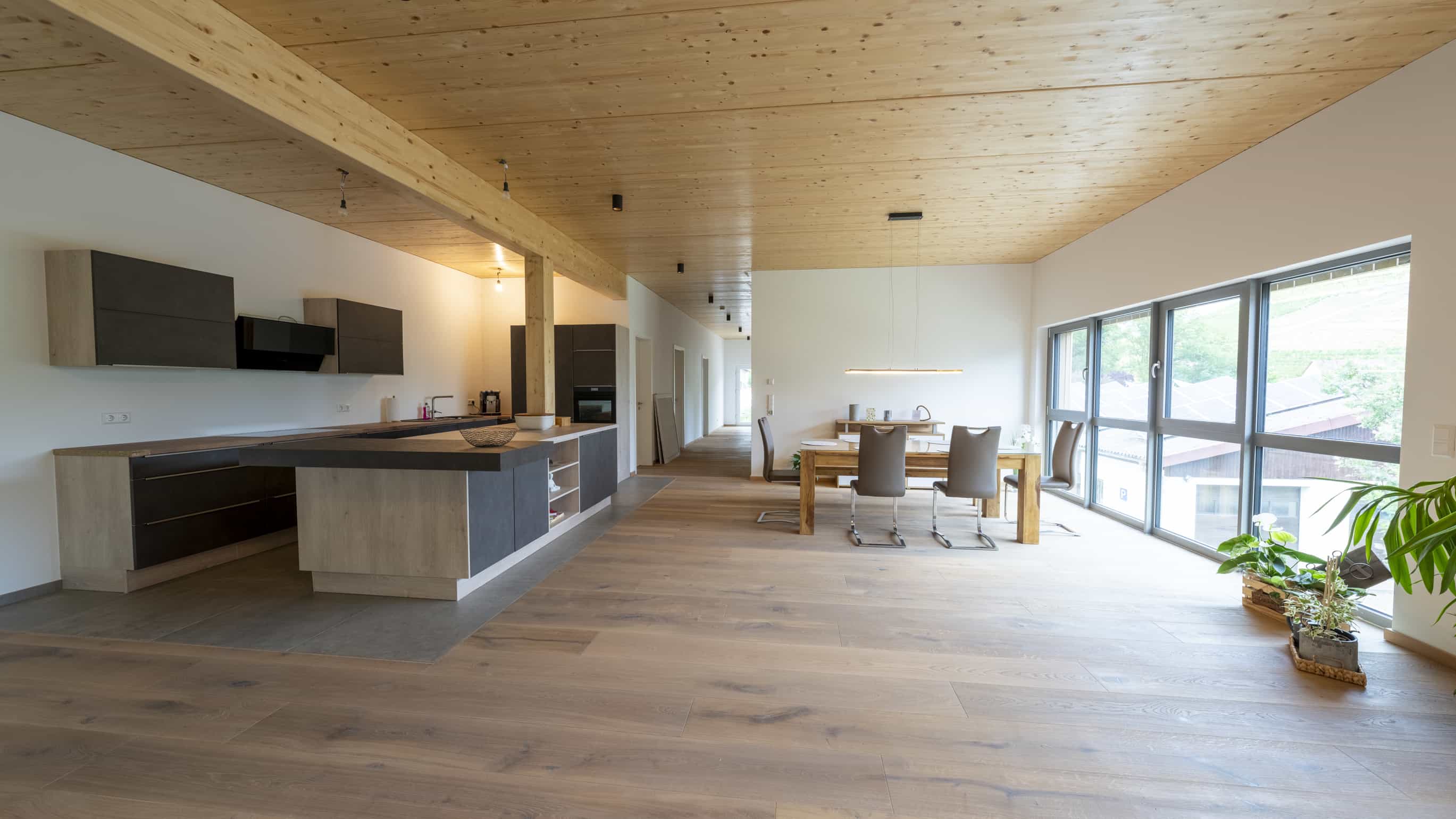 Offener Wohnbereich mit Küche und Holzdecke in der Geschäftsleiterwohnung der Weinwirtschaft Burgblick