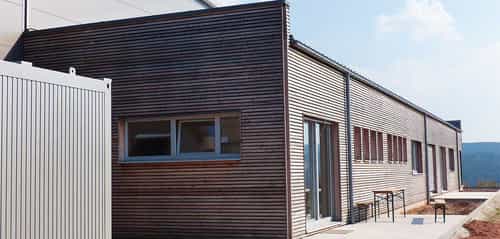 Anbau des Bürogebäudes in Walderbach mit Holzlamellenfassade und Fensterband, Außenansicht Haas Holzbausysteme
