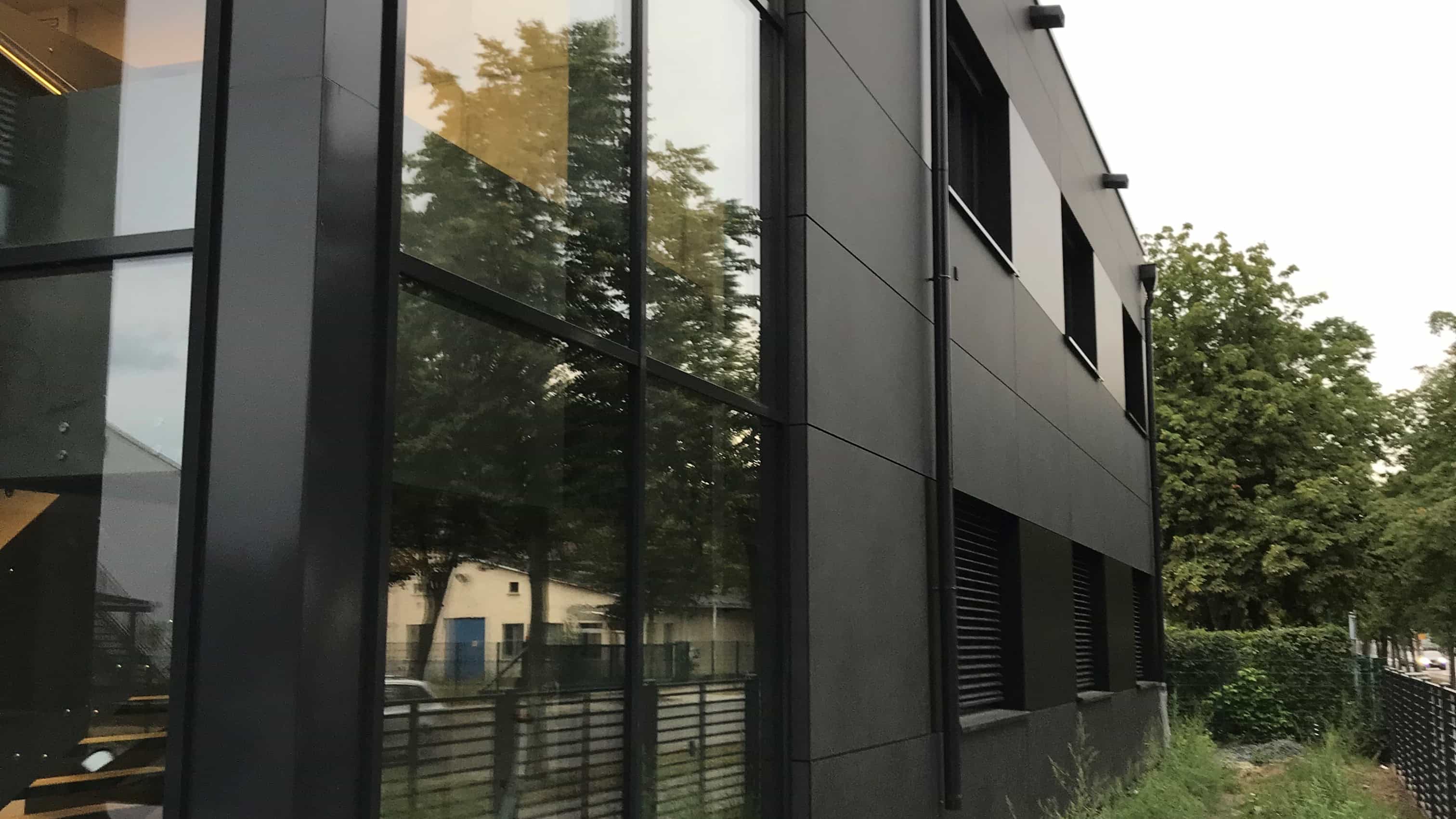 Fassadendetail des Gesundheitszentrums Steidten in Oranienburg mit dunklen Fassadenplatten und Glasfront