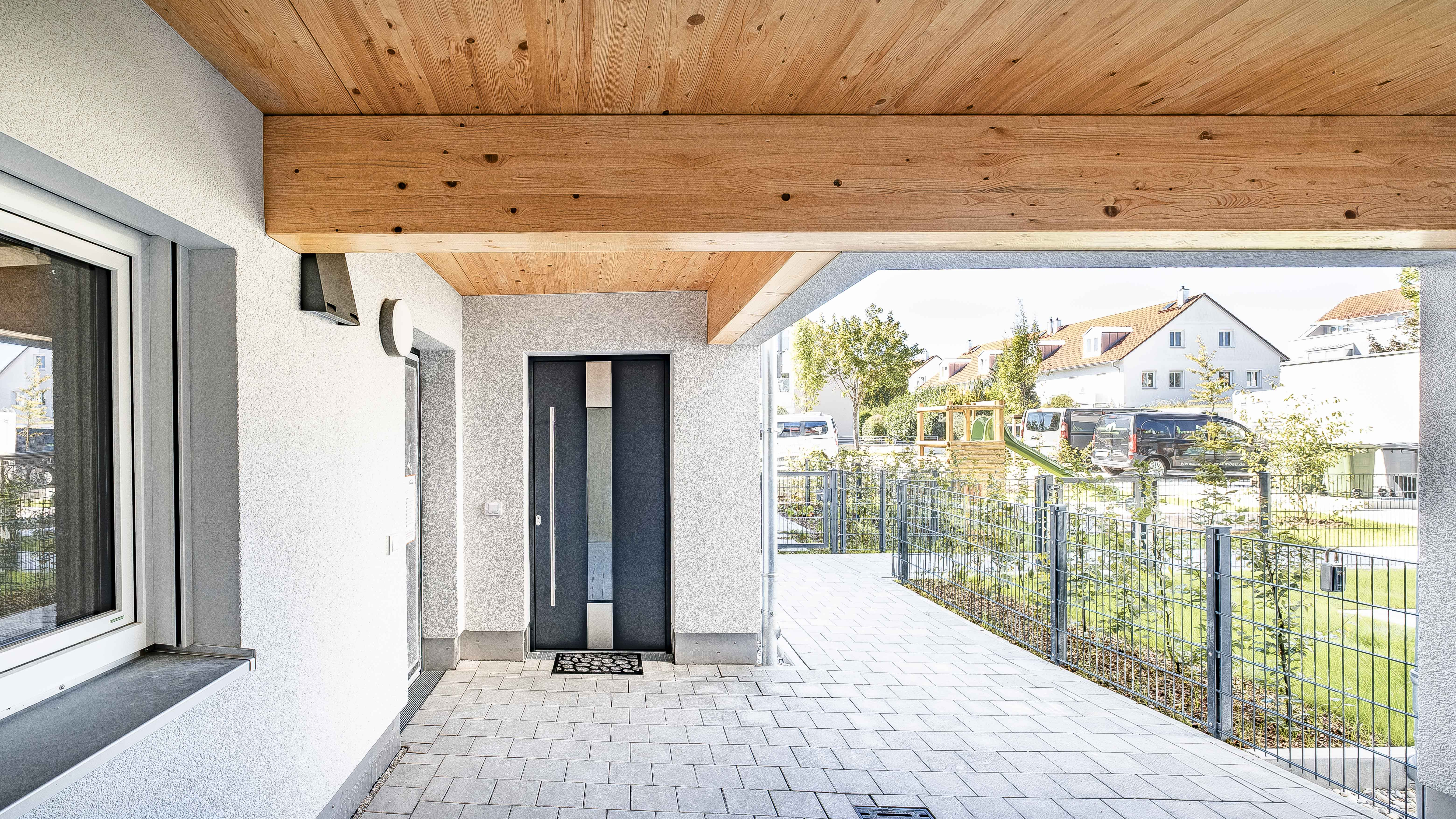 Überdachter Hauseingang mit Holzdecke und Holzträger an der Wohnanlage mit 15 Wohneinheiten in Eching