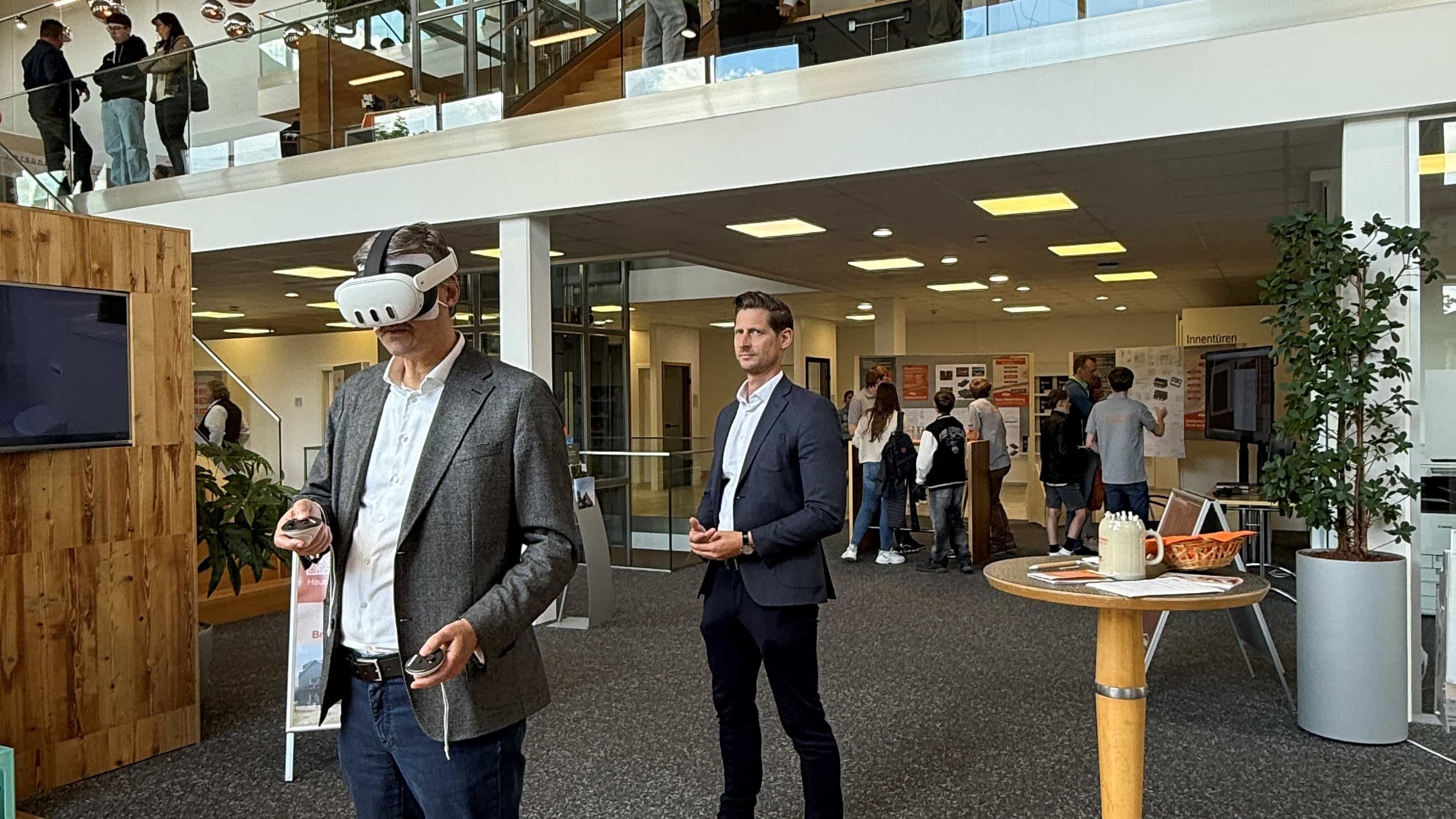 Person trägt VR-Headset in modernem Büro mit mehreren Menschen auf zwei Etagen.