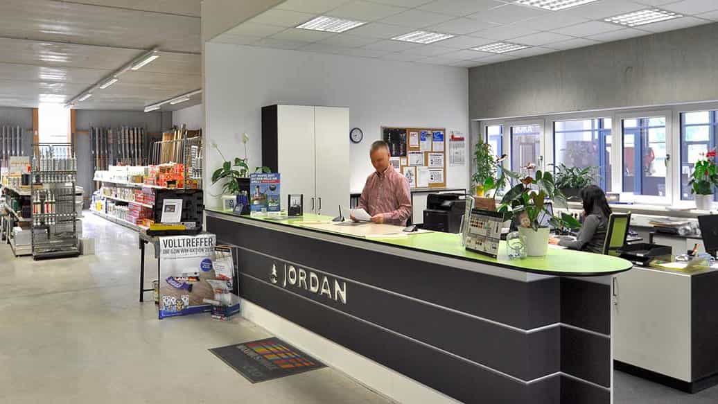 Empfangstresen mit Jordan Schriftzug und zwei Mitarbeitern im Verkaufsraum