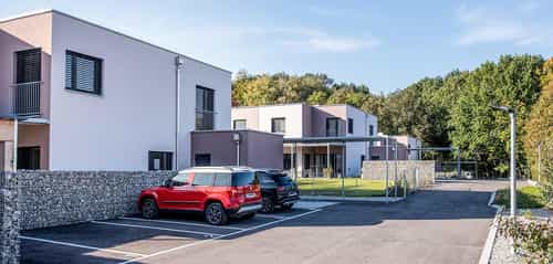 Doppelhausanlage mit 6 Wohneinheiten in Eichgraben mit Parkplätzen und Gabionenmauer