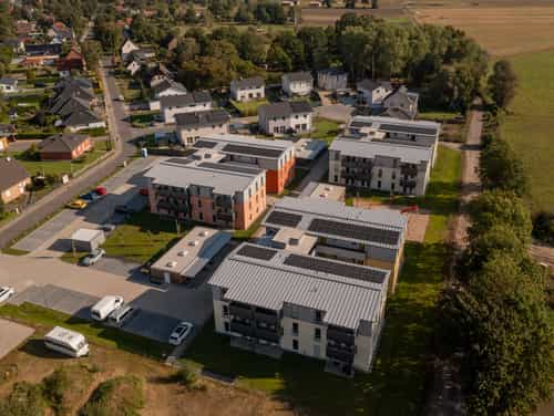 Luftaufnahme des Wohnquartiers Zum Glück Bötzow mit Mehrfamilienhäusern und Einfamilienhäusern im Havelland