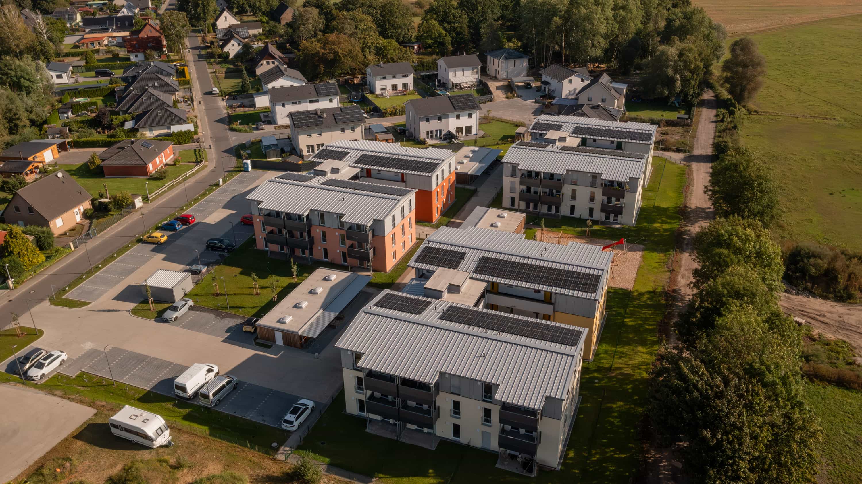 Luftaufnahme des Wohnquartiers Zum Glück Bötzow mit Mehrfamilienhäusern und Einfamilienhäusern im Havelland