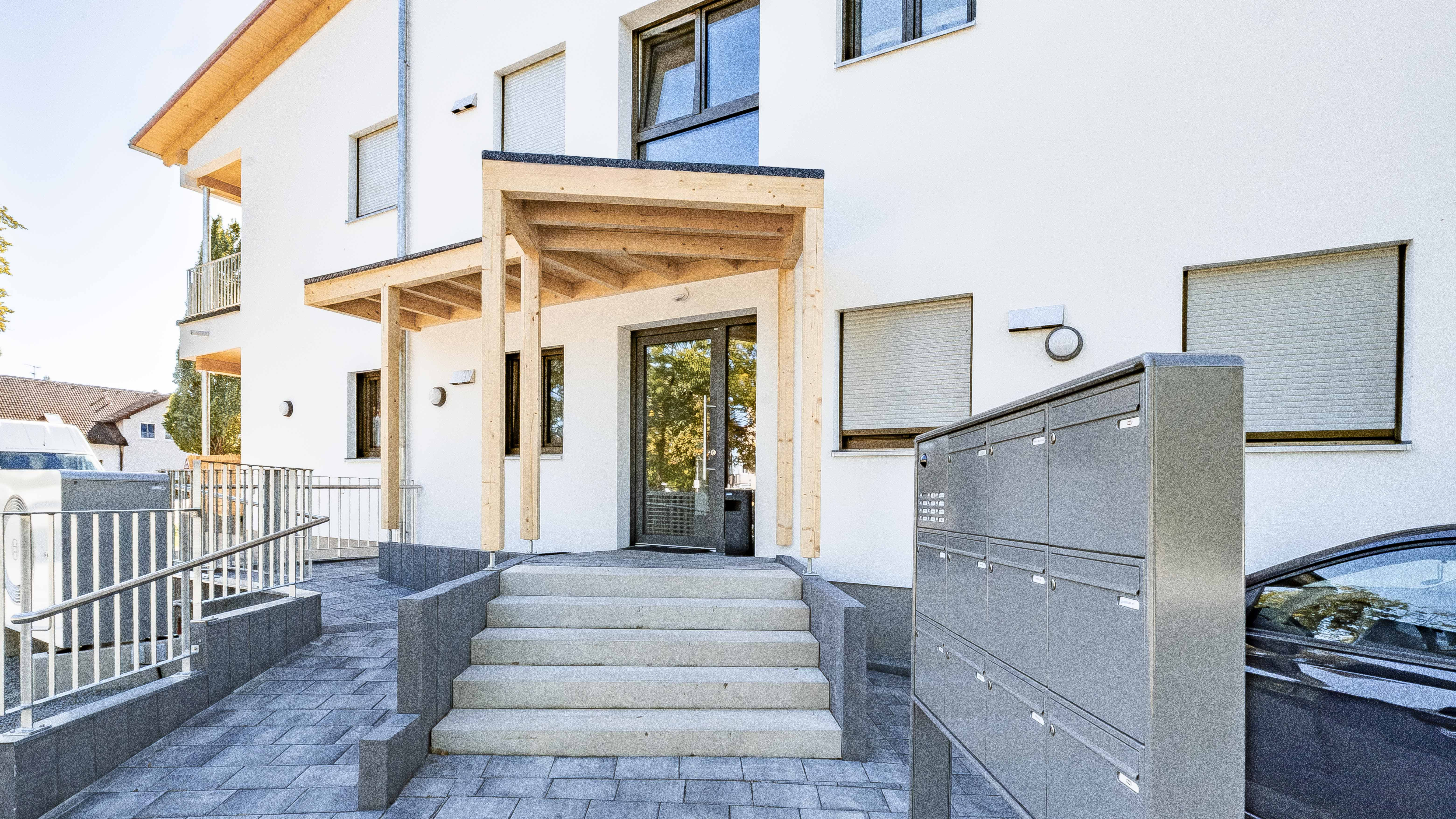 Hauseingang mit Treppe, Briefkastenanlage und Holzvordach der Wohnanlage mit 10 Wohneinheiten in Eichendorf