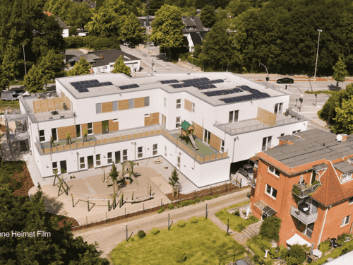 Luftaufnahme der Kita KD1 von Haas Gewerbebau mit Photovoltaik auf dem Flachdach und Spielplatz