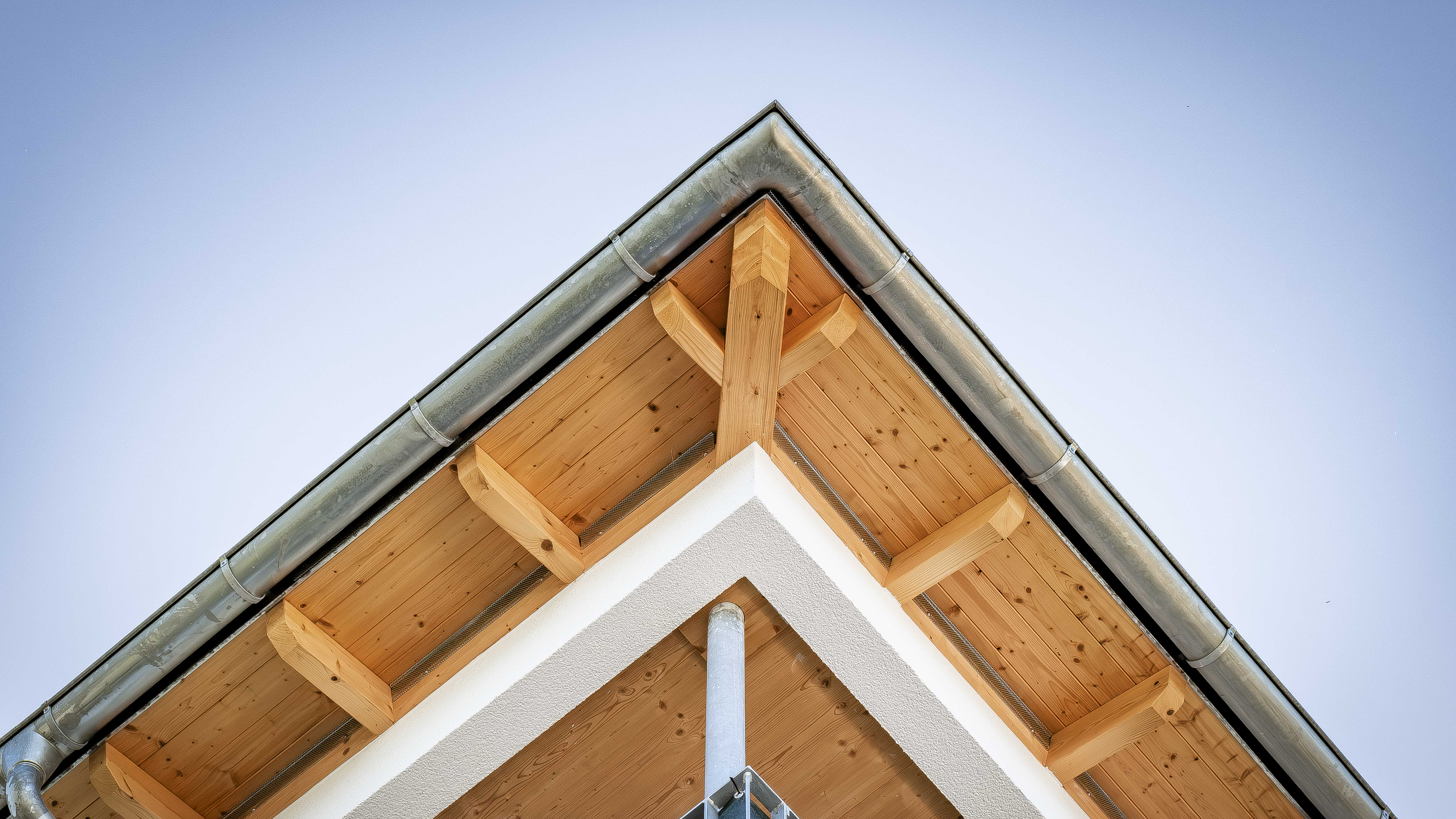 Detail des Dachgiebels mit sichtbaren Holzsparren an der Wohnanlage in Eichendorf von Haas Wohnbau